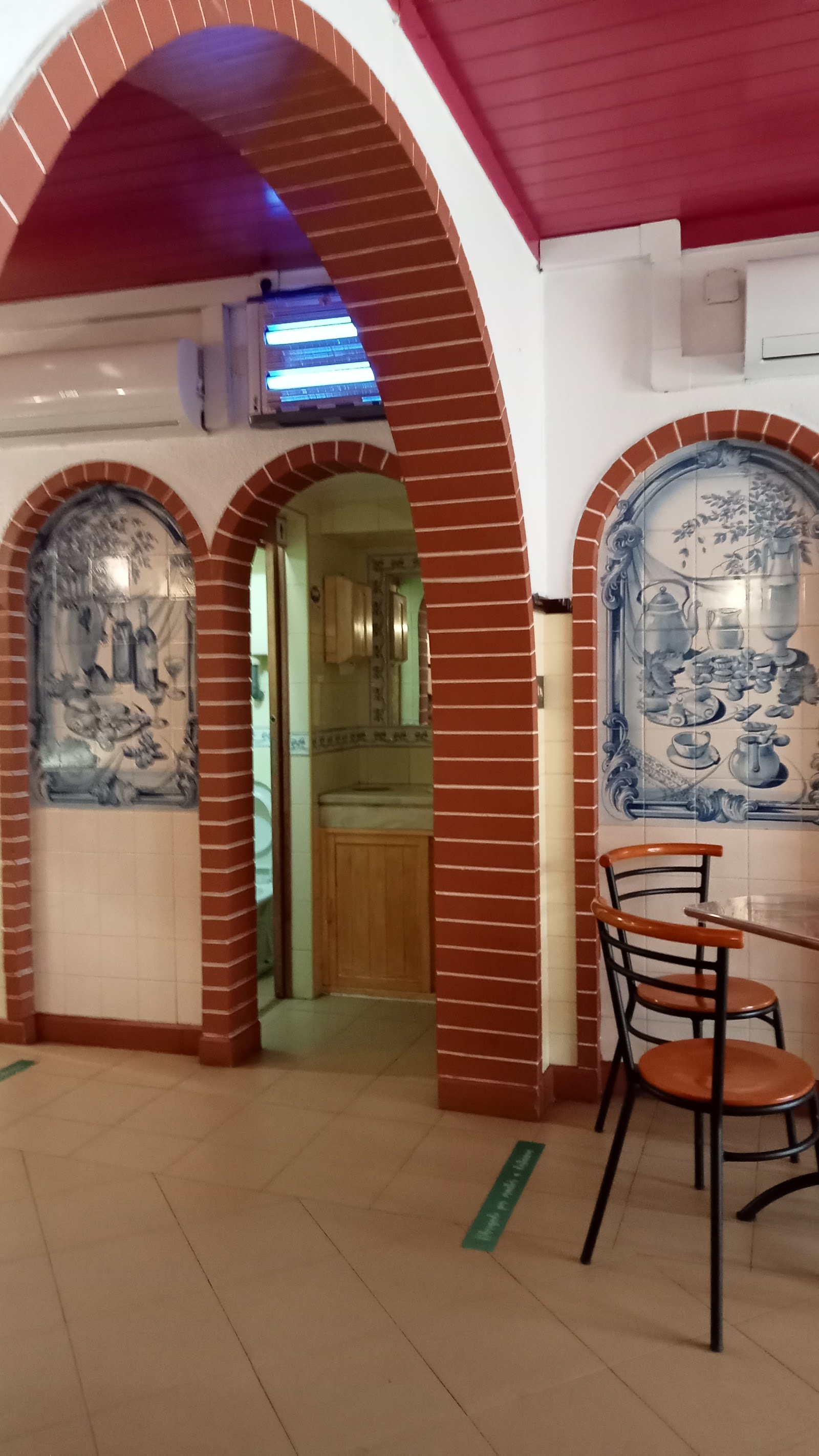Interior com painéis de azulejo azul e arcos de tijolo